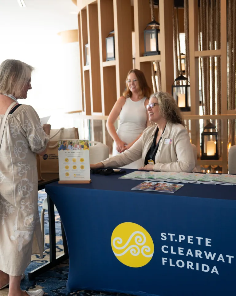 Woman at the desk of a Visit St. Pete-Clearwater Booth