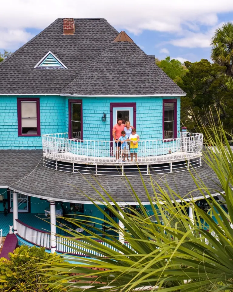 a family standing on the balcony of the Victorian-style 1910 Inn in Tarpon Springs