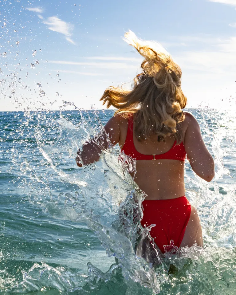 a young woman splashing into the Gulf at a beach in St. Pete-Clearwater