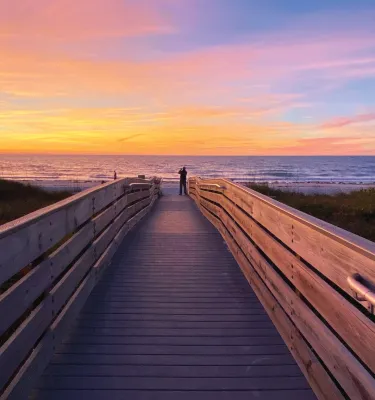A man taking a photo of the colorful sunset in Indian Rocks Beach