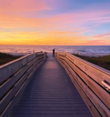 A man taking a photo of the colorful sunset in Indian Rocks Beach