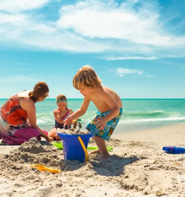 Uma família construindo um castelo de areia na praia em Treasure Island.