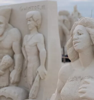 Uma intrincada escultura de areia que mostra uma família primitiva como parte do Sanding Ovations, um festival anual de escultura em areia na Ilha do Tesouro.