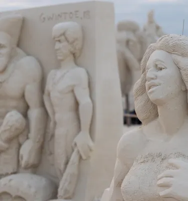 Uma intrincada escultura de areia que mostra uma família primitiva como parte do Sanding Ovations, um festival anual de escultura em areia na Ilha do Tesouro.