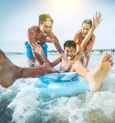 A family plays in the water near Pier 60 in Clearwater Beach, Florida