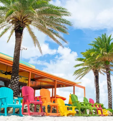 Um conjunto de cadeiras coloridas do lado de fora do Frenchy's Rockaway Grill em Clearwater Beach
