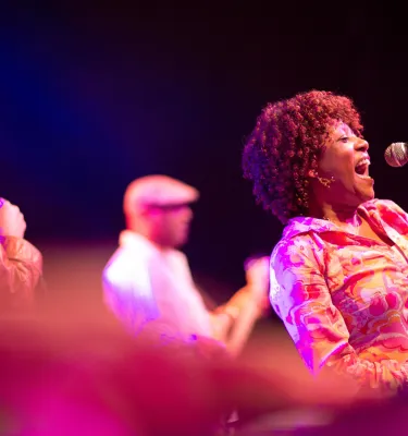 Uma mulher afro-americana cantando no Jannus Live em St. Pete.
