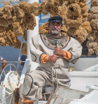 Um mergulhador de esponjas em um barco com muitas esponjas em Tarpon Springs.