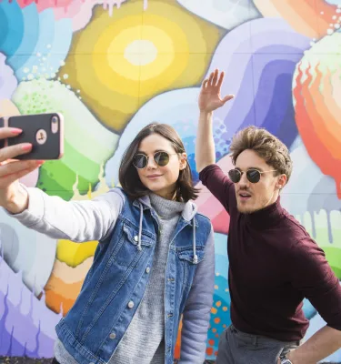 Zwei Personen machen ein Selfie vor einem Wandgemälde im Block 600 der Central Avenue