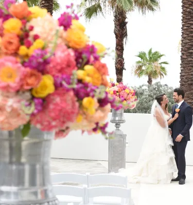 A big flower arrangement outside of Wyndham Grand Hotel. Bride and groom can be seen in the background.