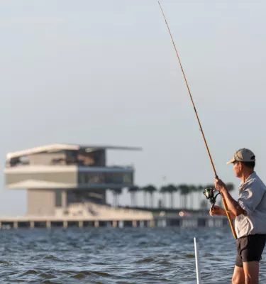 A man fishing at North Shore Park near the St. Pete Pier.