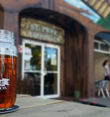 A beer glass on top of a table outside of St. Pete Brewing Co.