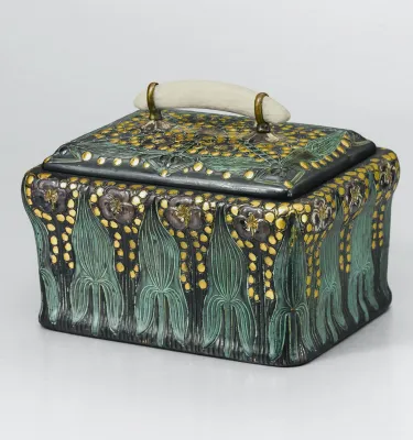 A small black ceramic box that is hand-painted with green and gold accents.