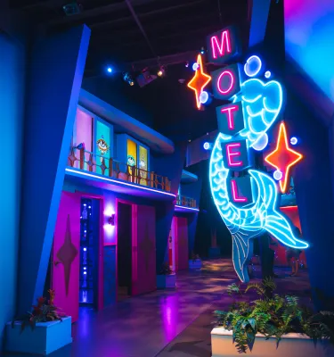 Eine Leuchtreklame vor einer künstlerischen Nachbildung eines Vintage-Hotels in Florida