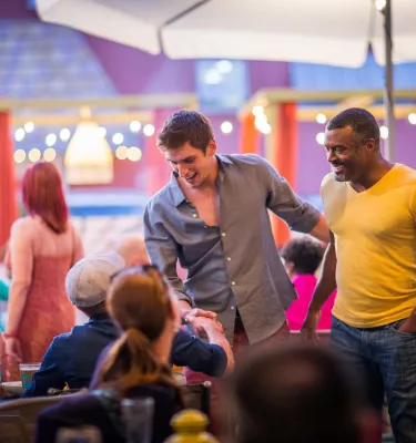 A couple men greet friends at a LGBT+ Bar and Restaurant