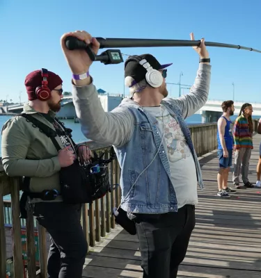 Television crew filming a scene of the show Life's Rewards on the boardwalk in John's Pass on a sunny Florida day.