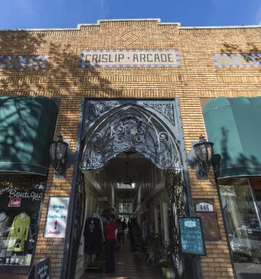 Outside shot of the Crislip Arcade featuring brown brick walls and green building shades. 