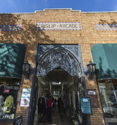 Outside shot of the Crislip Arcade featuring brown brick walls and green building shades. 