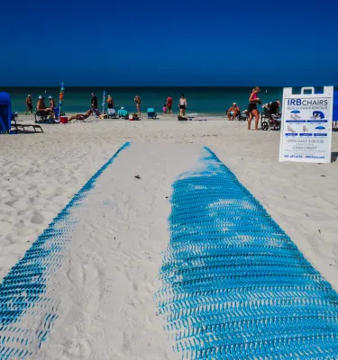 um Mobi-Mat azul brilhante com areia se estende em direção ao Golfo em Indian Rocks Beach