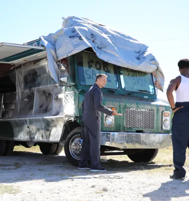 actors in a scene with a broken vehicle