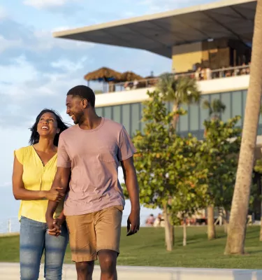 Pareja tomados de la mano frente al edificio St. Pete Pier