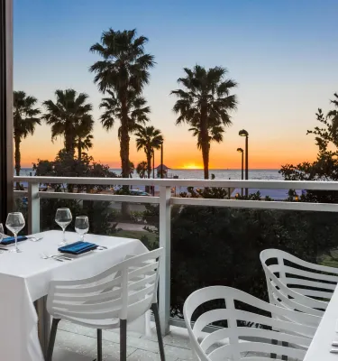 white chairs and a table with a white table cloth at Ocean Hai restaurant overlook sunset at the beach