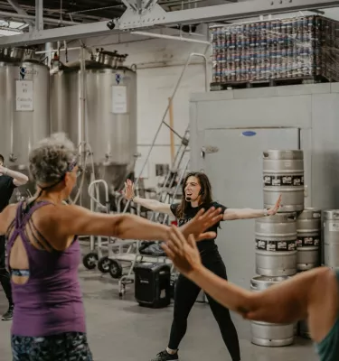 Woman with black hair instructing moves during an Irish dance class.