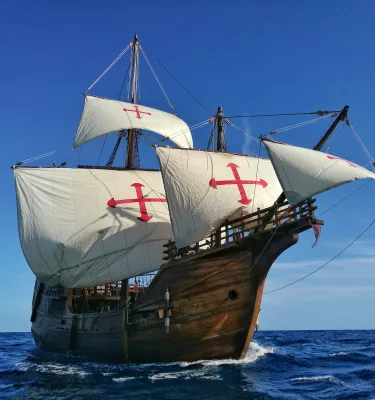 A tall ship with billowing white sails