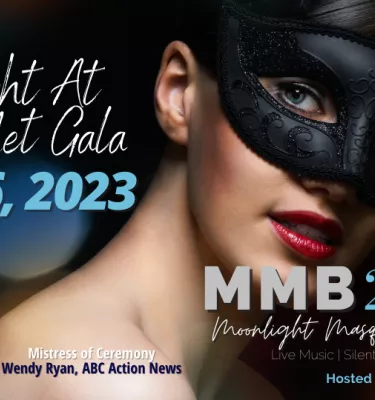 Woman staring at the camera in a black masquerade mask.