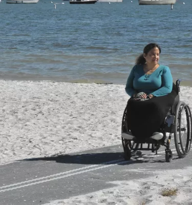 Woman in wheelchair on Mob-Mat on the beach