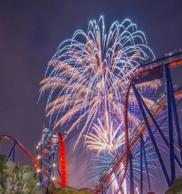 Fireworks at night in front of red roller coaster at Busch Gardens Tampa Bay.