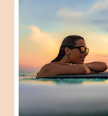 a cream color block next to a lady on a paddleboard watching the sunset