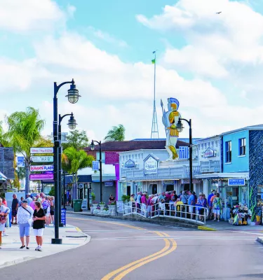 Lots of people line the street in Tarpon Springs, waiting to get into shops and restaurants.