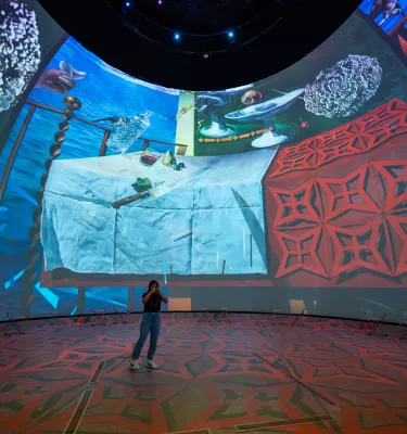 Dome projection with woman in front of it 