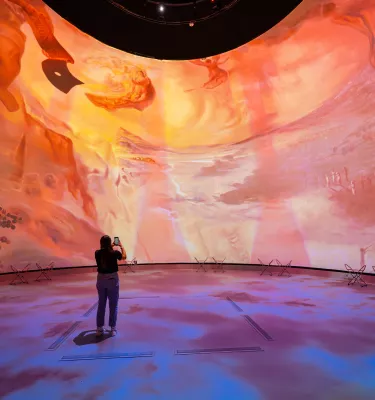 Dome projection with woman in front of it 