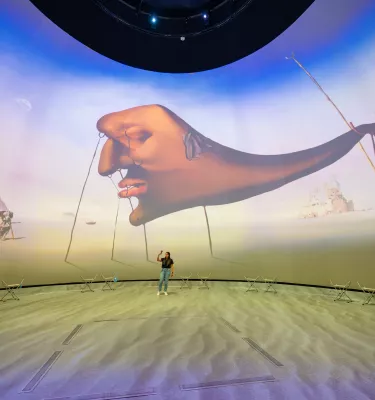 Dome projection with woman in front of it 