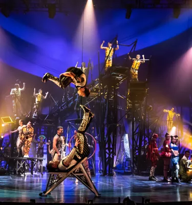 Cirque du Soleil show featuring a group of acrobats on stage performing stunts.