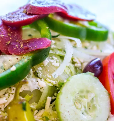 colorful greek salad with beets, green peppers, tomatoes, onions, feta cheese