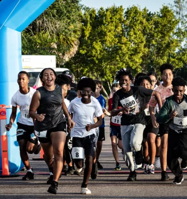 Group of joggers running on a track outside.