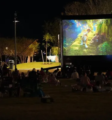 Outside movie screening featuring a group of people watching a movie.