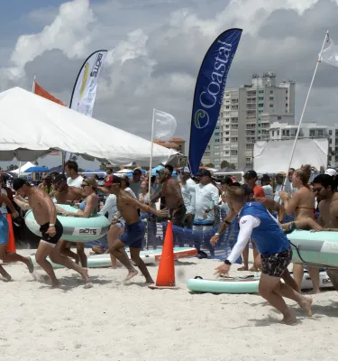 Company teams playing beach games during the day.