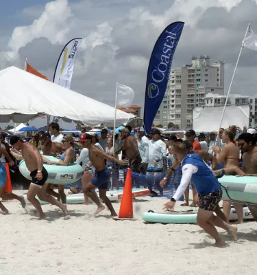 Company teams playing beach games during the day.