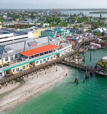 an aerial view of John's Pass Village & Boardwalk, a pier and a large boat