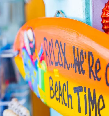 A colorful store sign says Relax, We're on Beach Time