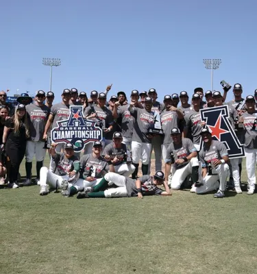 Winning college baseball team photo on the field.
