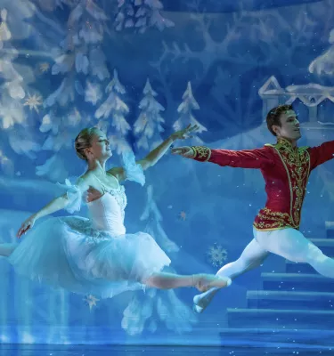 Nutcracker the Christmas Ballet featuring two ballet dancers jumping on stage.