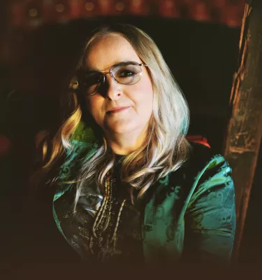 Melissa Etheridge in smoky glasses and a green shirt