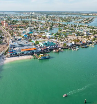 aerial view of john's pass village with a bridge on the left and green inlet waters on the right