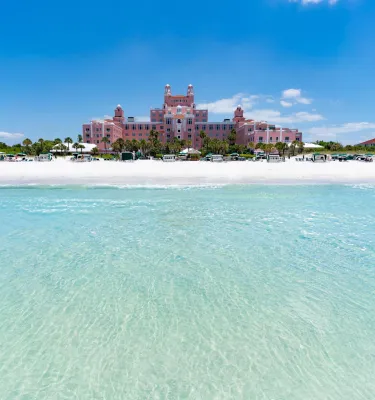 the pink Don CeSar resort with white sand beach and clear green waters in front