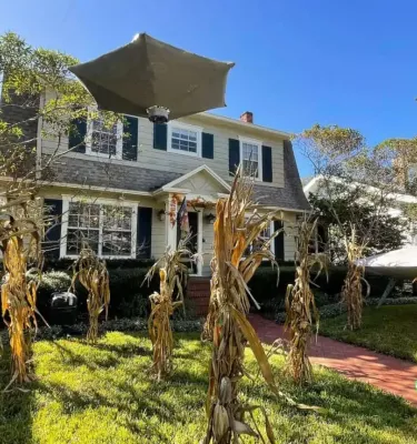 Photo of a house with halloween decorations outside featuring aliens and scarecrows.